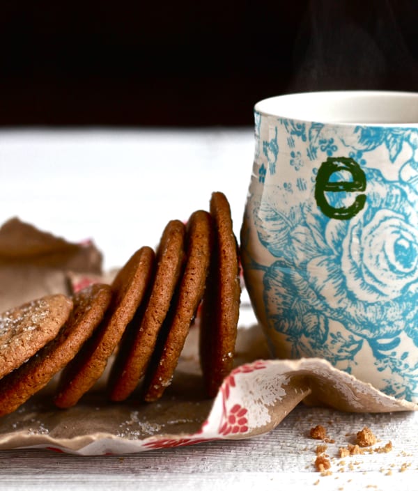 Gingernut cookies next to a coffee cup.