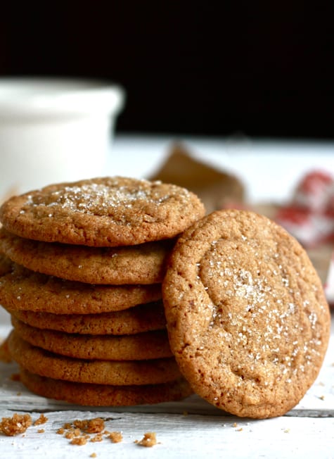 Stacked gingernut cookies on a white board.