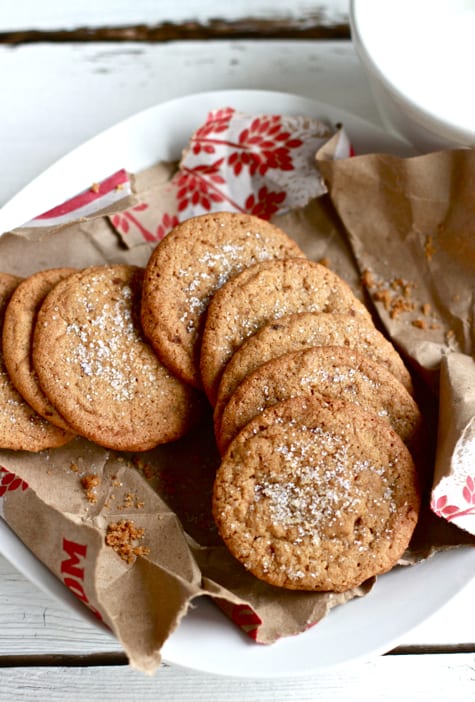 Gingernut cookies in a bowl lined with brown parchment paper.