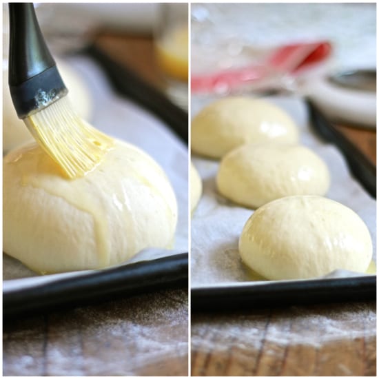 Pastry brush with egg wash on top of brioche hamburger buns 
