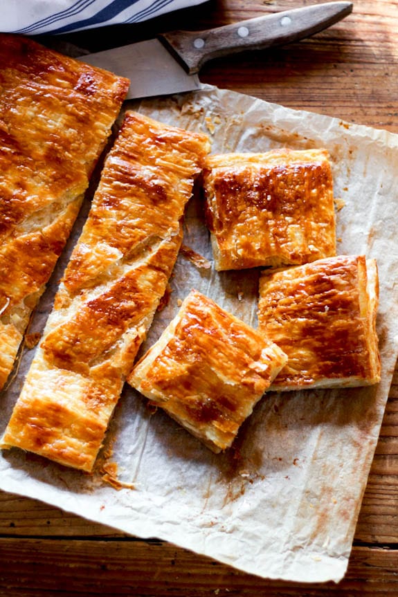 Baked ham and cheese puff pastry appetizer cut into squares.