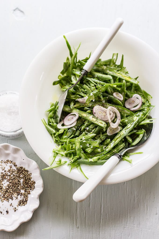 French cut green beans in a bowl with shallots.