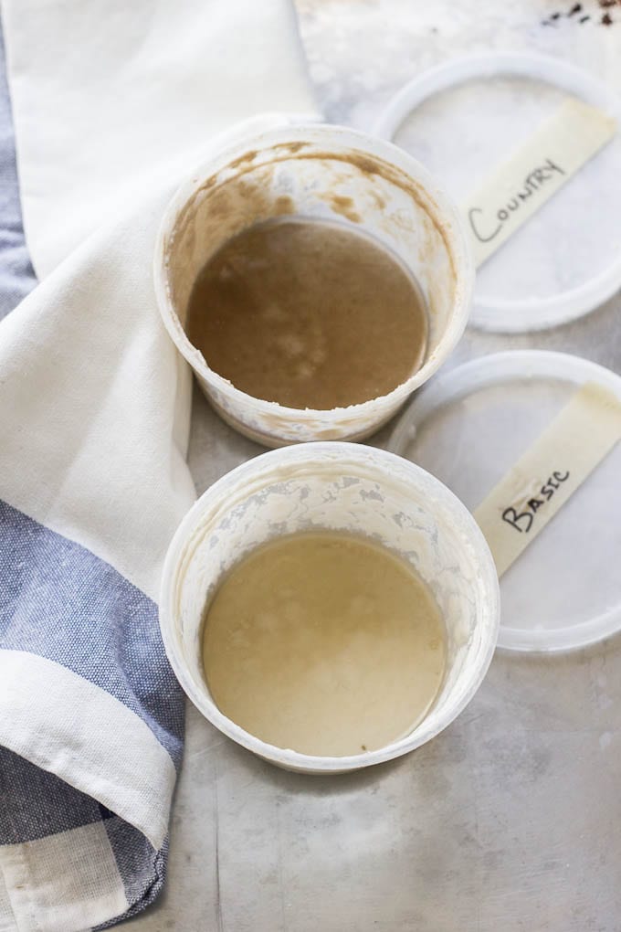 Sourdough starter with hooch, dark gray liquid in a container