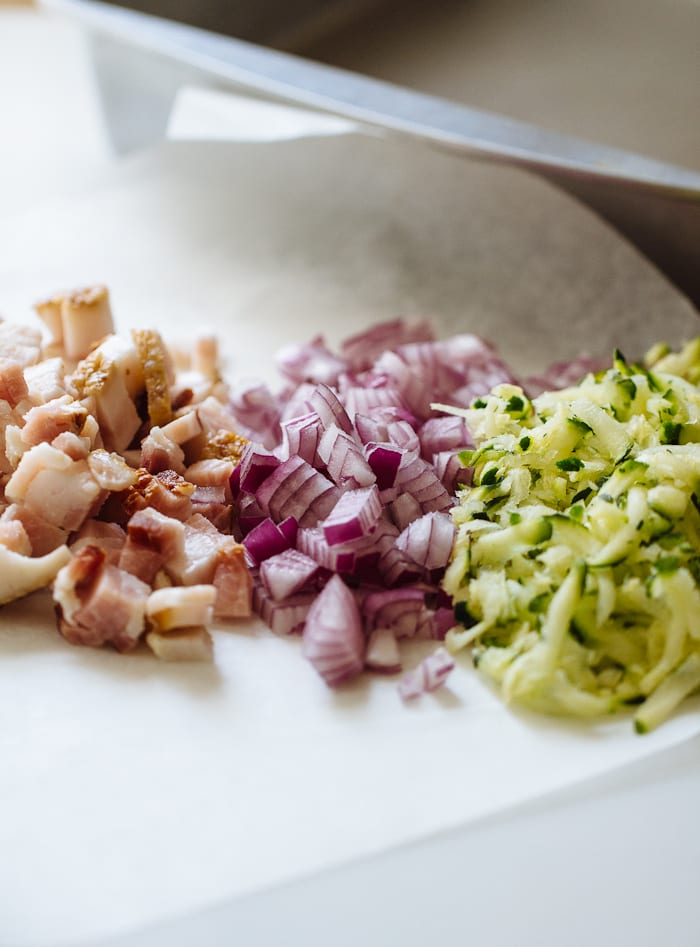 Zucchini slice ingredients: bacon, red onion and shredded zucchini