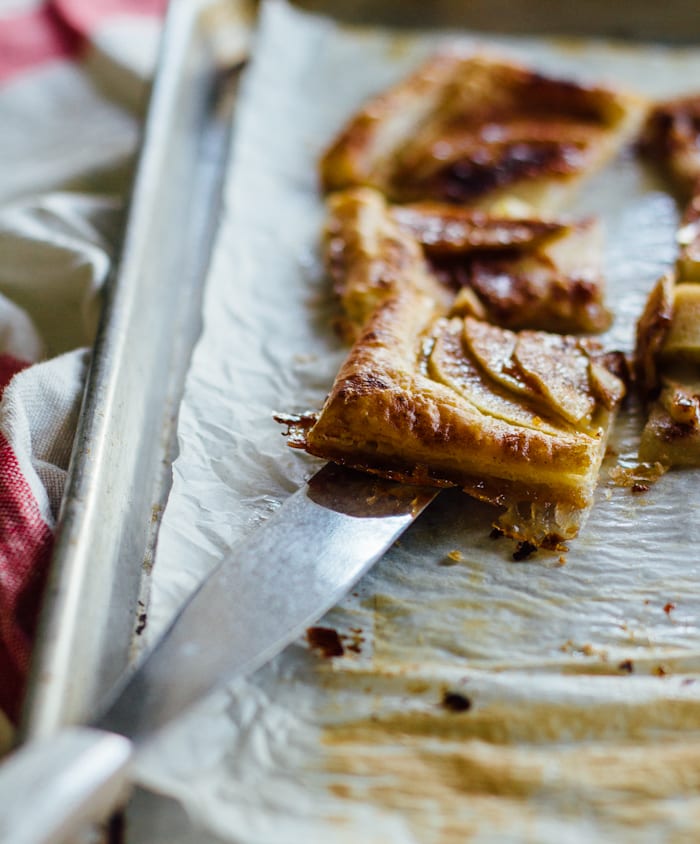 Slice of easy apple tart with puff pastry with caramelized edges