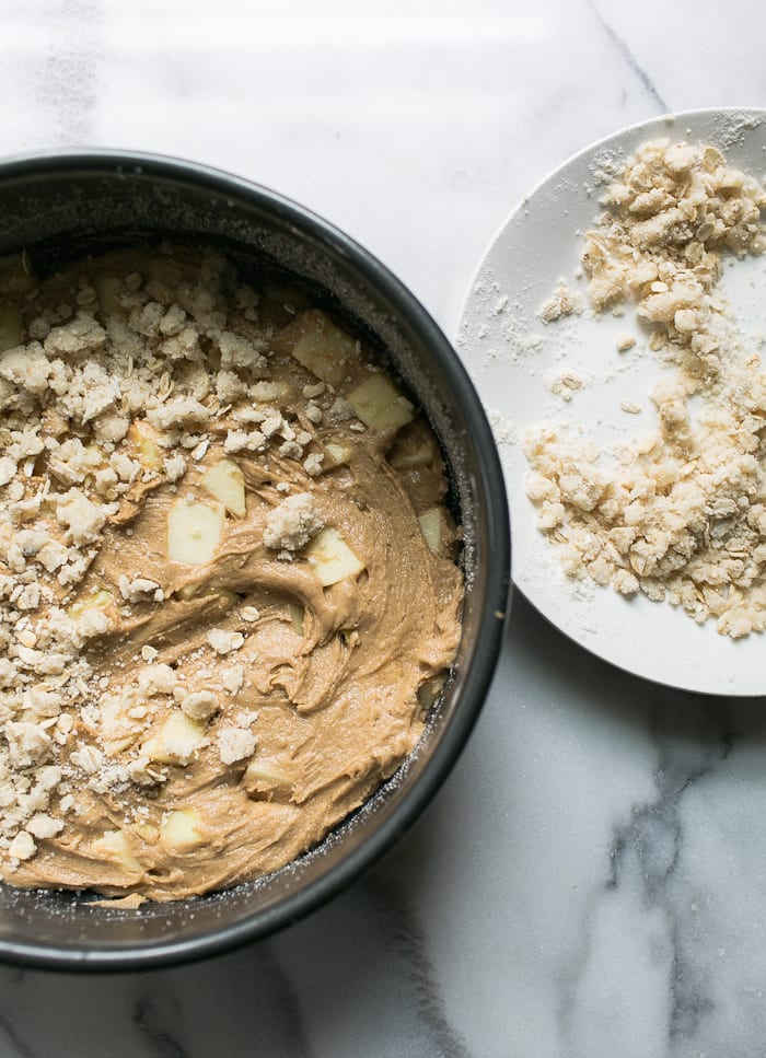 Cake pan filled with apple cake batter and crumble topping