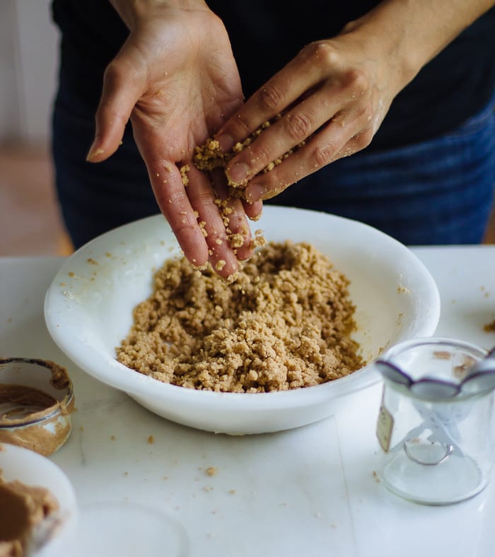 Hands rubbing crumble topping ingredients together