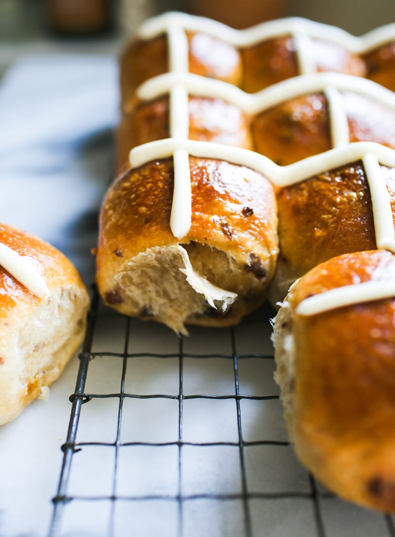 Sourdough hot cross buns with cream cheese icing on a wire rack