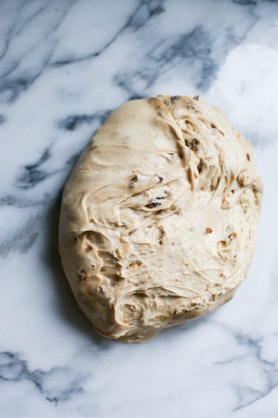 Soft, sourdough hot cross bun dough on a marble surface