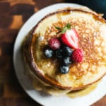 Stack of light and fluffy sourdough discard pancakes with fruit on top