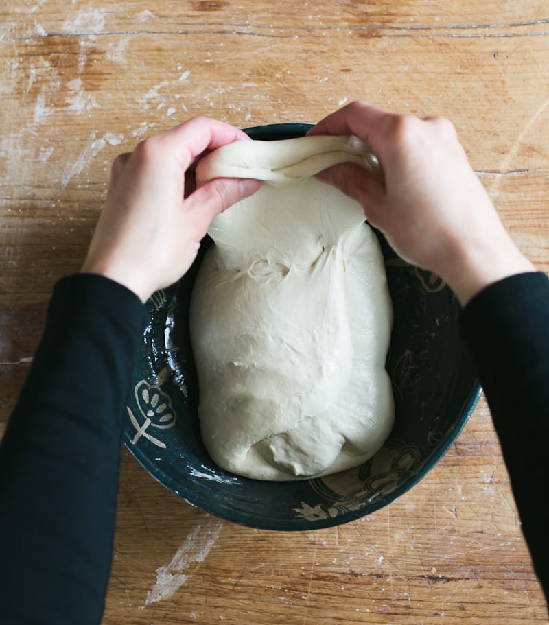 Stretching sourdough bread dough in a bowl