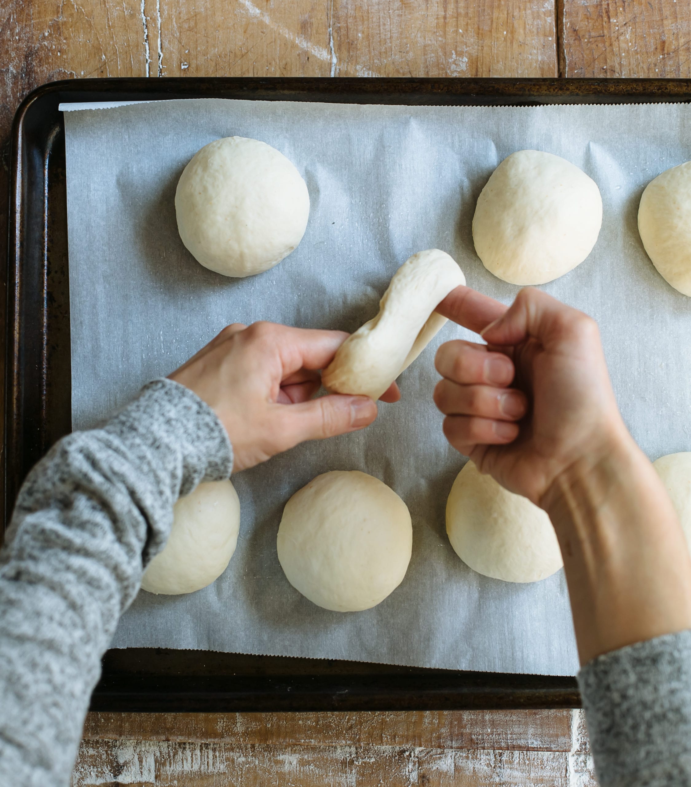 Shaping sourdough bagel dough.