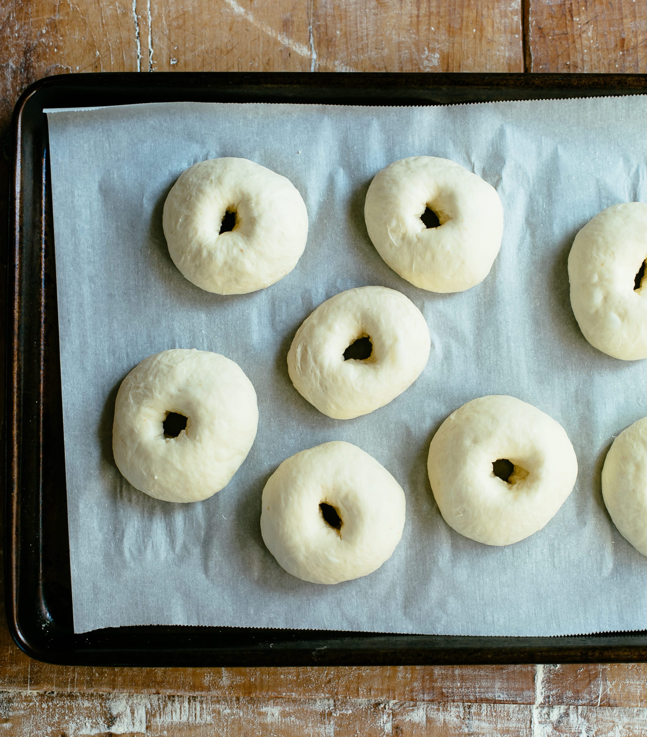 Sourdough bagel dough resting on a sheet pan.