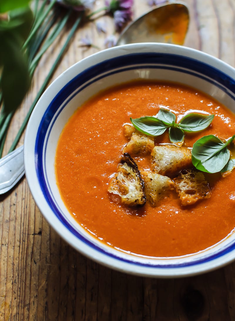 Blue and white bowl of tomato soup with sourdough croutons