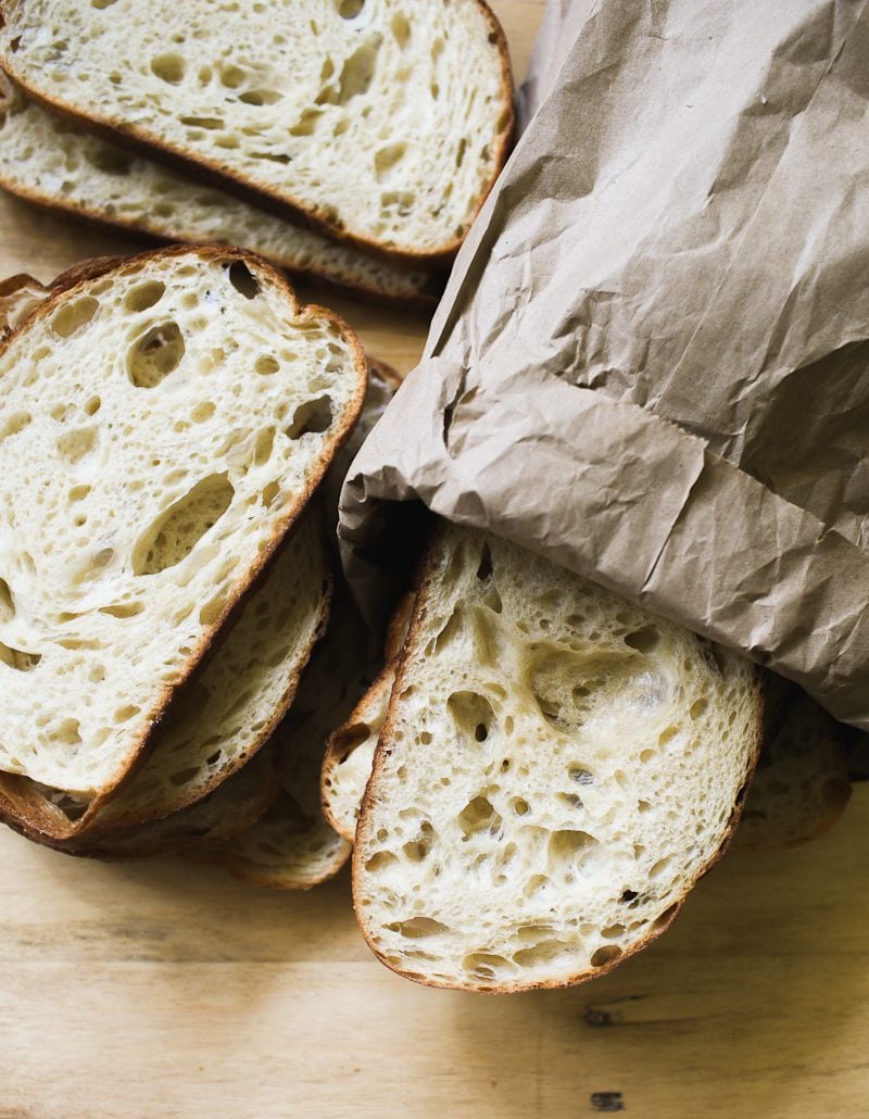 Slices sourdough bread stored in a brown paper bag.