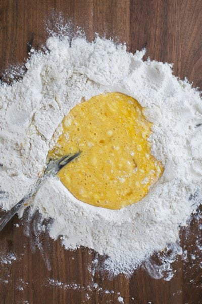 Mixed eggs and flour on a wood board