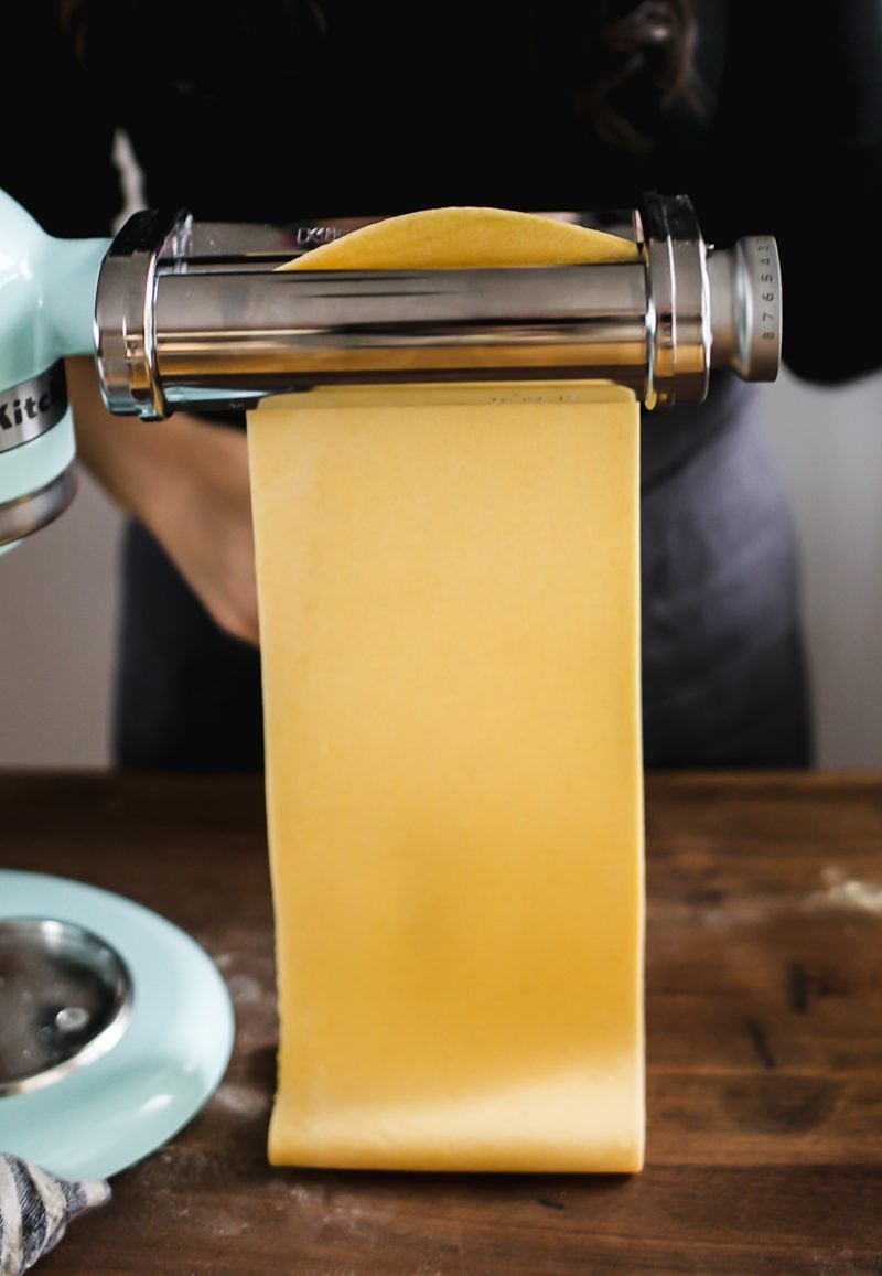 Fresh homemade pasta dough going through Kitchen Aid roller attachment