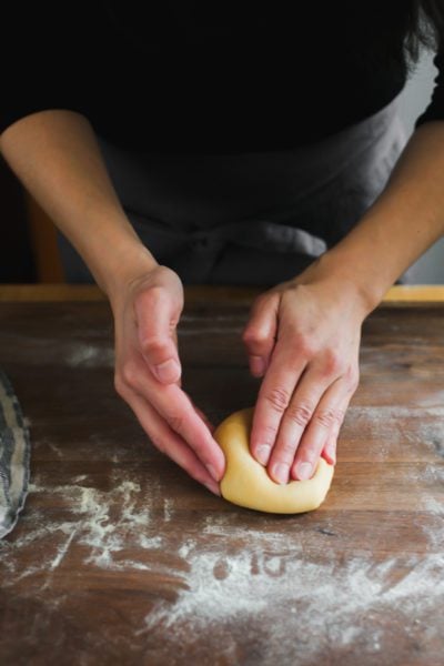 Flattened pasta dough into an oval shaped disc