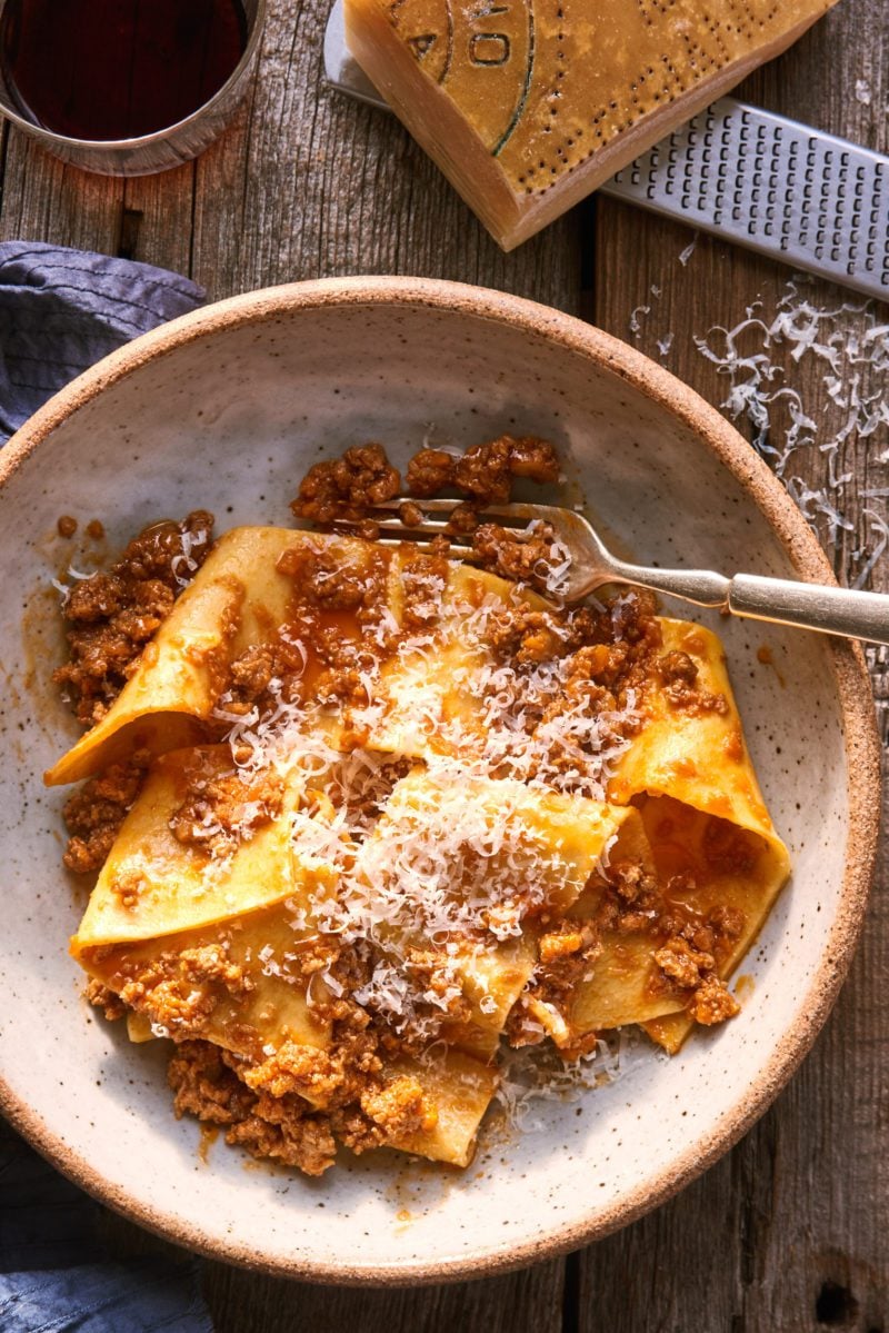 Bowl of fresh homemade pappardelle pasta with Ragù Bolognese sauce and Parmesan cheese.