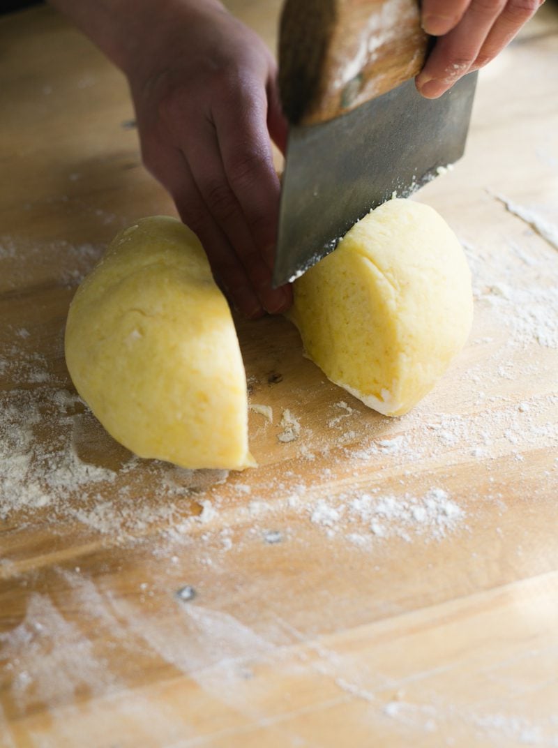Cutting the gnocchi dough with a bench knife.
