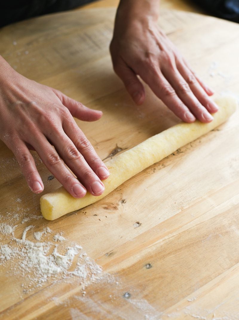 Rolling gnocchi dough into a log by hand.
