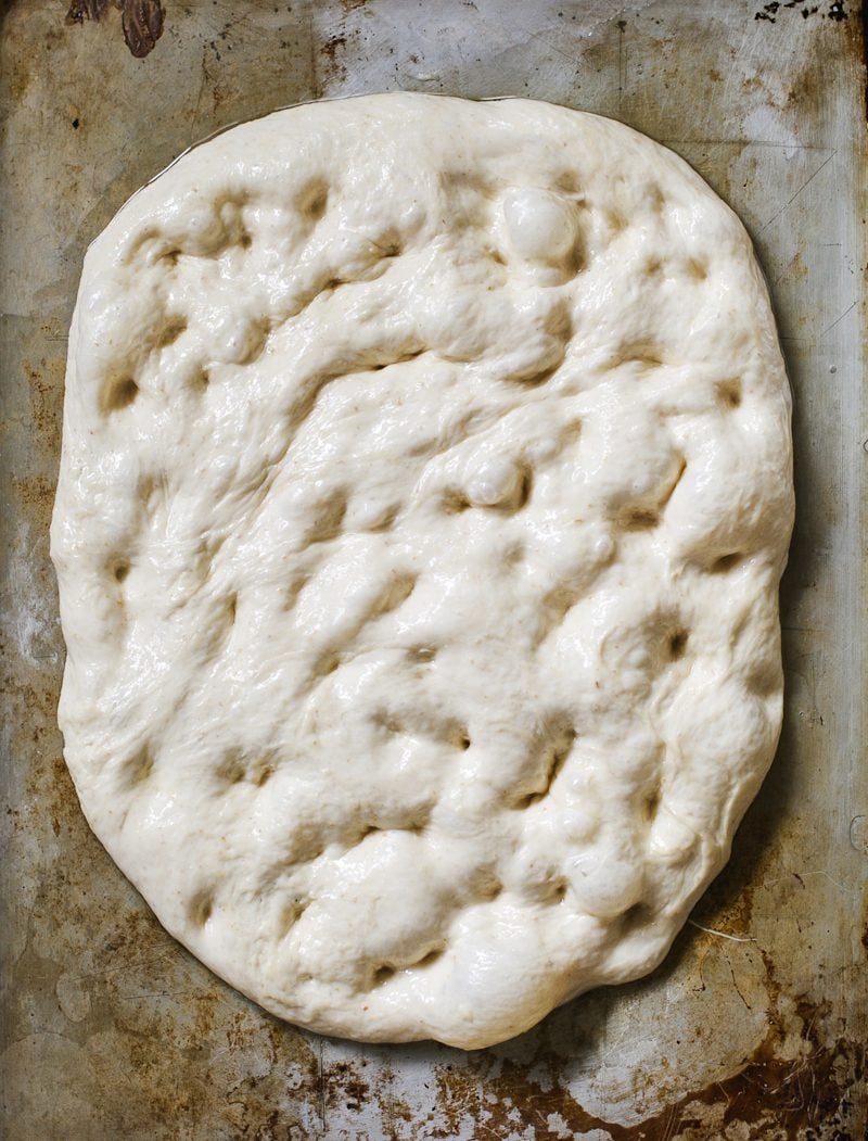 Dimpled sourdough focaccia dough on an oiled sheet pan