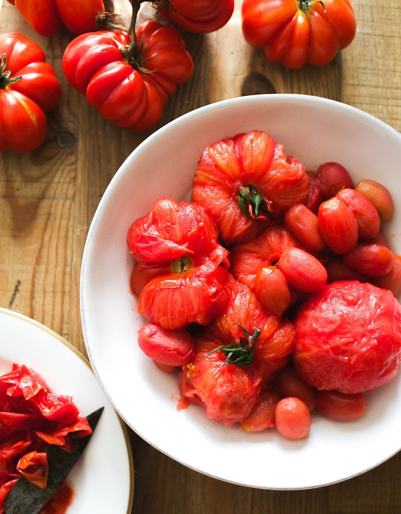 Blanched, skinless heirloom tomatoes in a bowl.