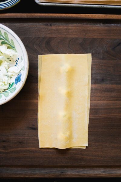 Assembled ravioli on a wooden surface.