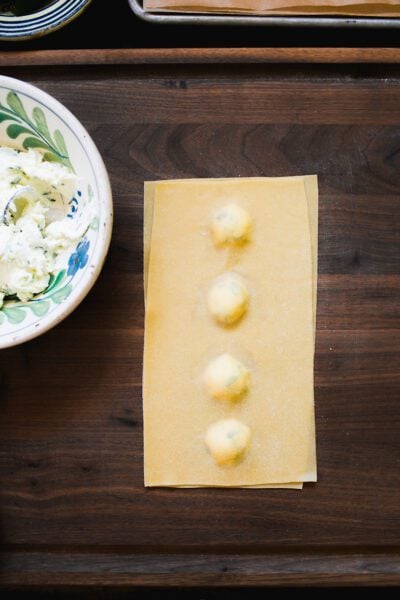 Assembled ravioli on a wooden surface with the air bubbles pressed out.