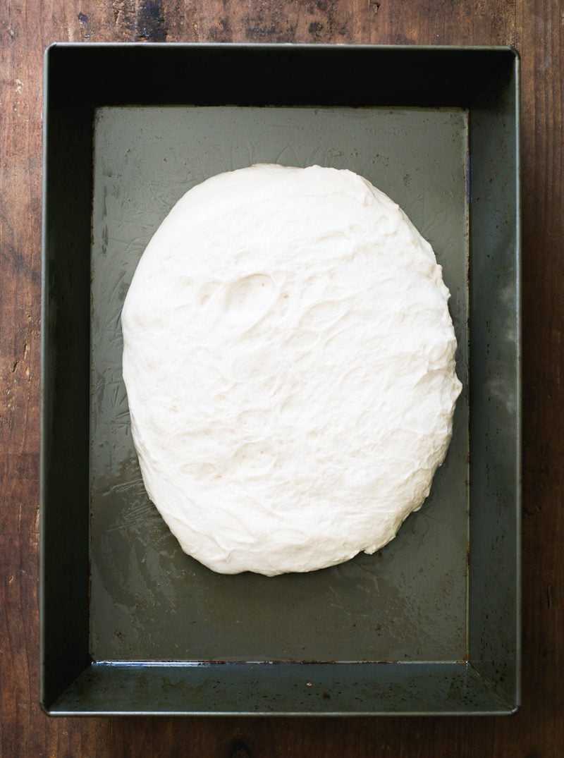 Sourdough pizza dough in a non-stick baking pan