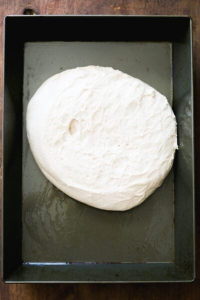 Sourdough pizza dough in a non-stick baking pan