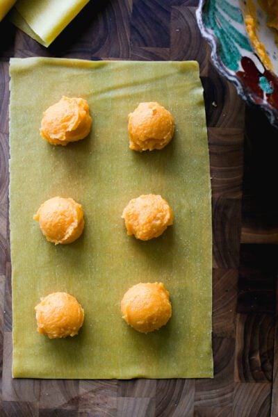 Butternut squash filling for ravioli dolloped on a fresh pasta sheet.