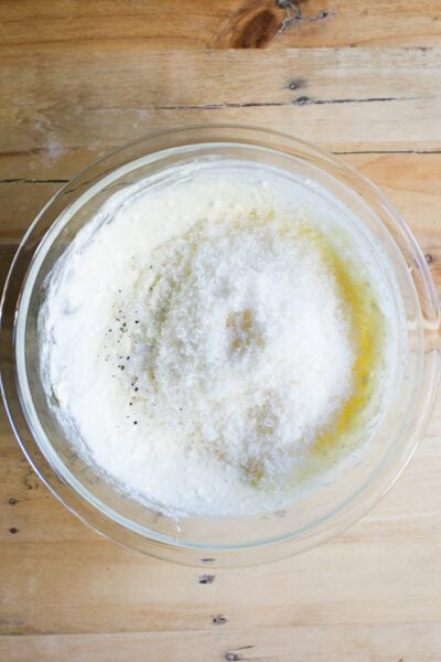 Parmesan cheese with ricotta mixture in a glass mixing bowl