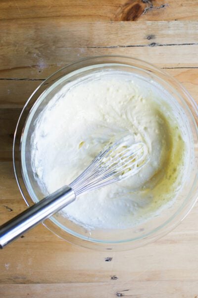Whisked ricotta and eggs in a glass mixing bowl
