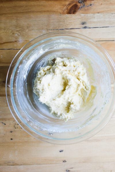 Ricotta gnocchi dough in a glass mixing bowl on a wooden surface