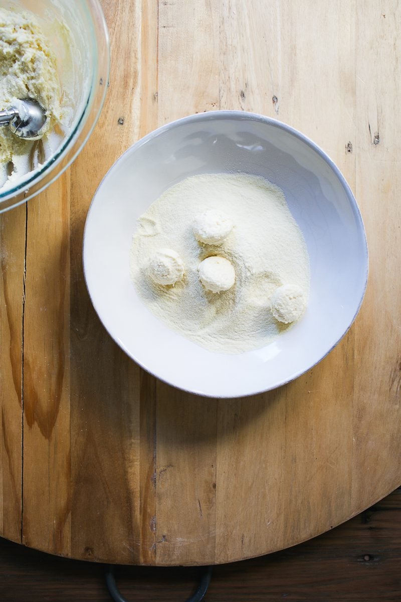Portioned ricotta gnocchi in a bowl of semolina flour