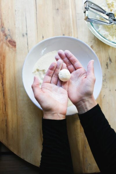 Two hands holding a ricotta gnocco