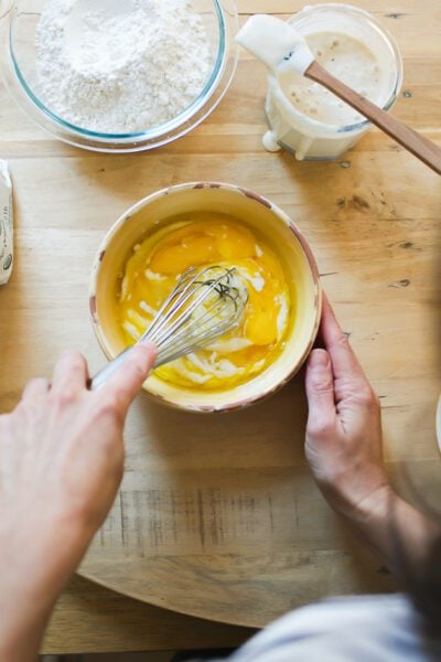 Whisked eggs and sourdough starter in a yellow bowl