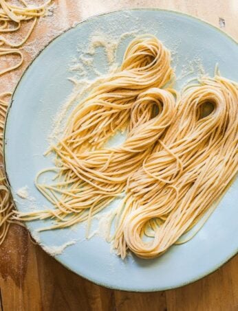 Homemade sourdough pasta strands on a blue plate