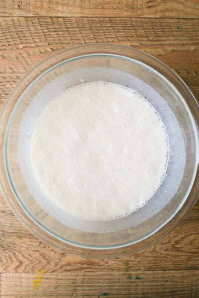 Sourdough starter and milk in a glass mixing bowl