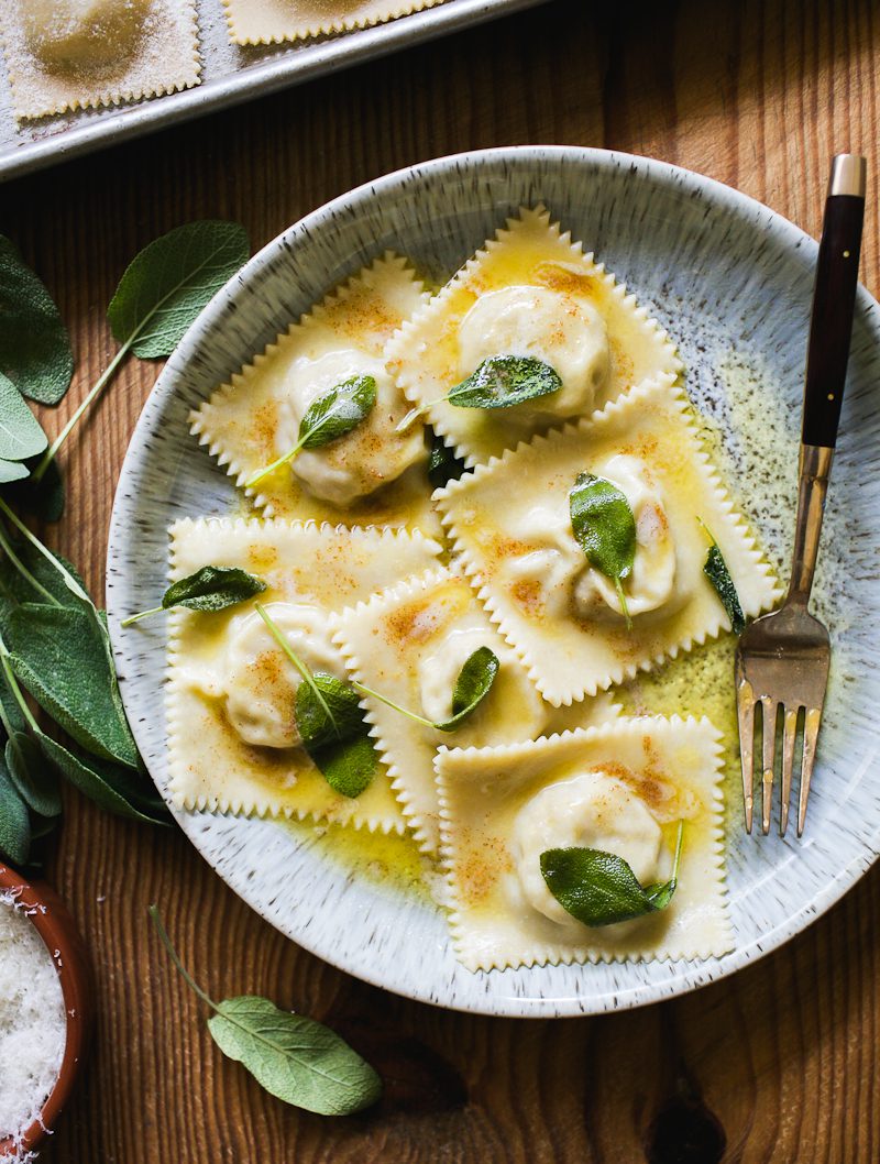 Italian meat ravioli with butter and sage pasta sauce in a shallow dish