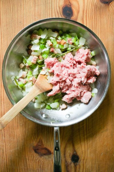 Cooked bacon, onions, celery, garlic, rosemary and ground pork in a skillet.