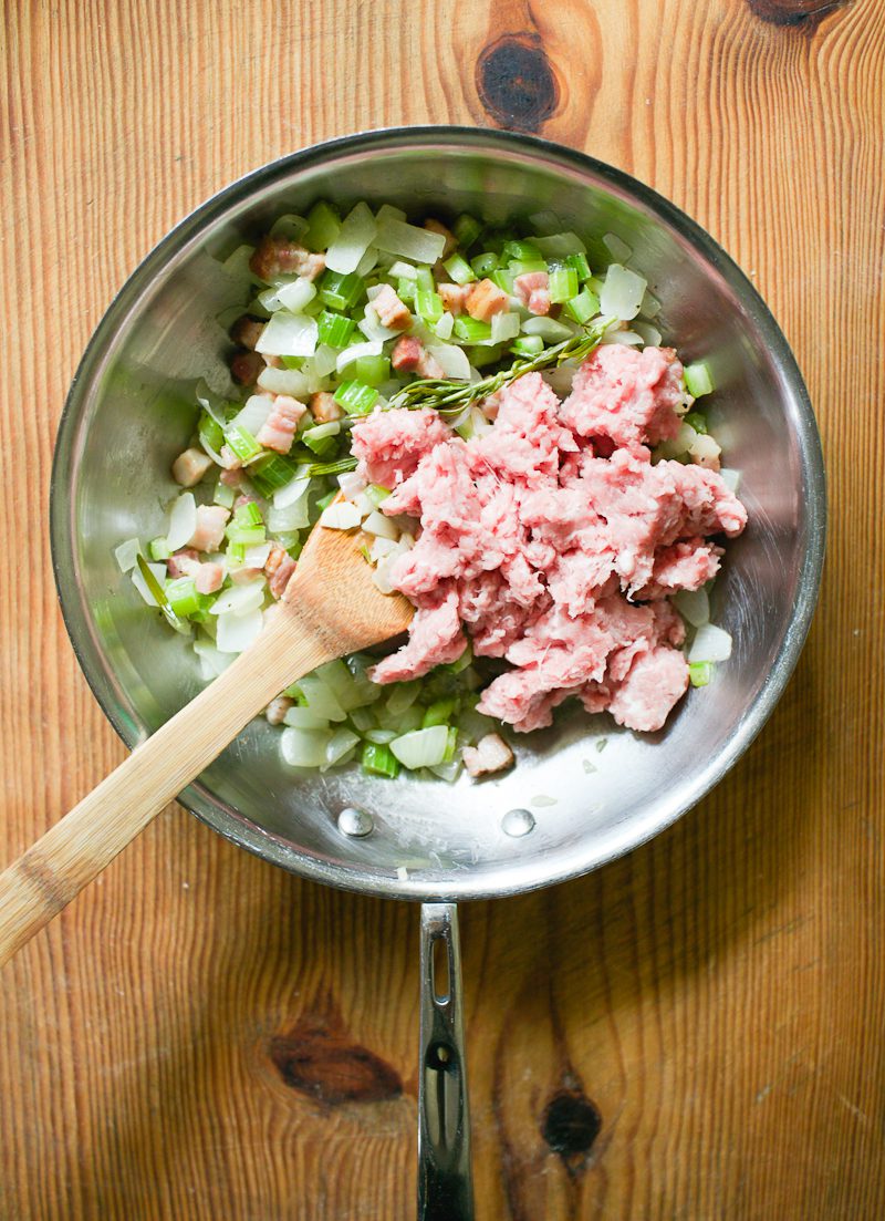 Cooked bacon, onions, celery, garlic, rosemary and ground pork in a skillet.