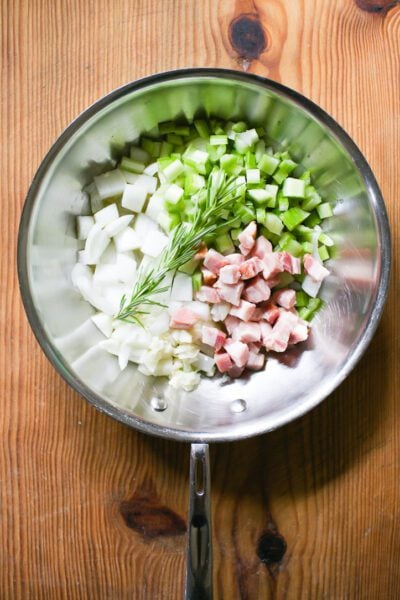 Diced bacon, onions, celery, garlic and rosemary in a skillet.