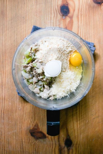Ground pork meat filling in a food processor with Parmesan cheese, egg, and breadcrumbs.