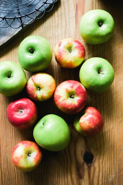 Red and green apples on a wooden board