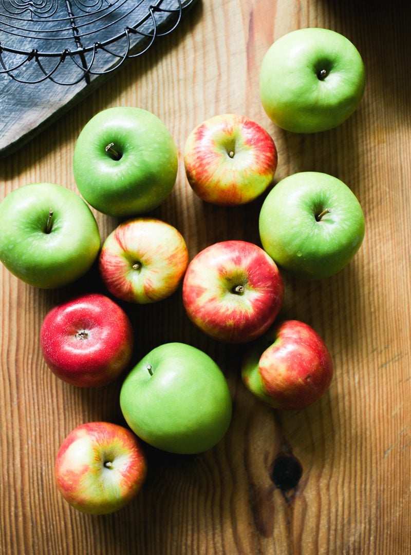 Red and green apples on a wooden board