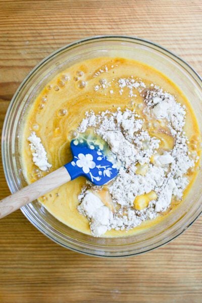 Dry ingredients combined with wet ingredients in a large mixing bowl
