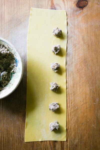 Rounded teaspoons of mushroom filling on a pasta sheet