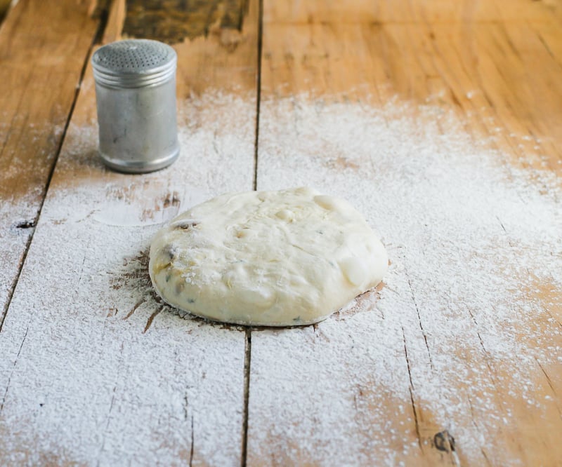 Sourdough garlic knot dough on a floured, wooden surface